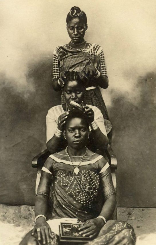 3 Black women braiding eachother's hair